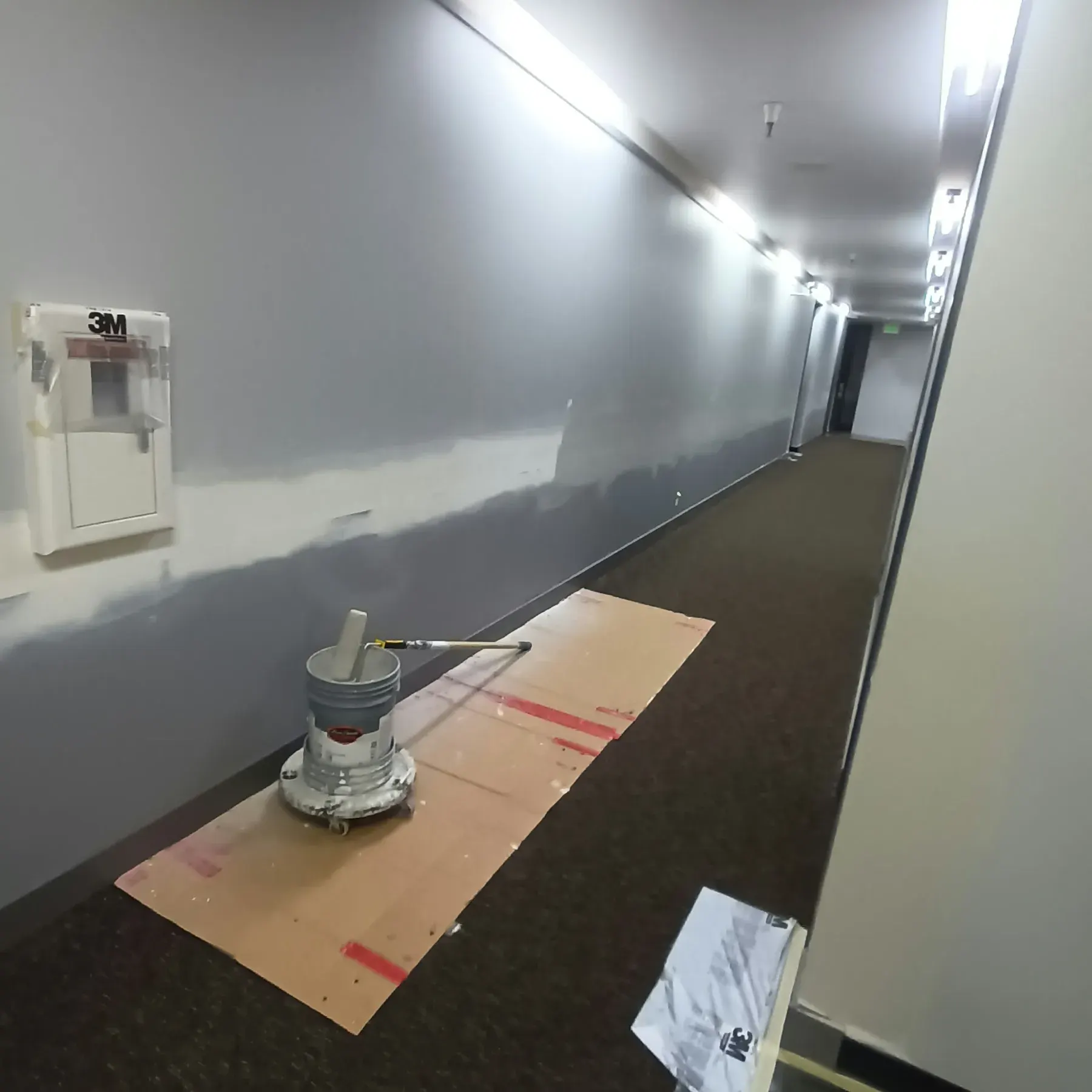 Commercial painting in San Jose, CA: corridor with carpet protected during a wall repaint