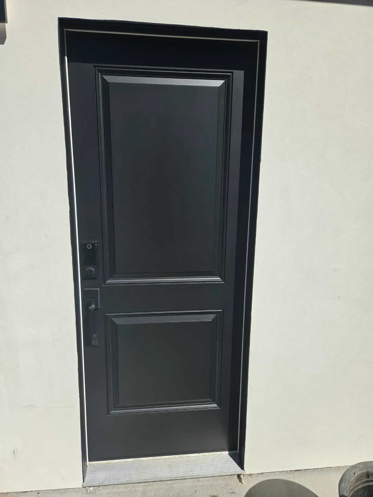 Door painting in San Jose, CA: black paneled entry door against cream stucco