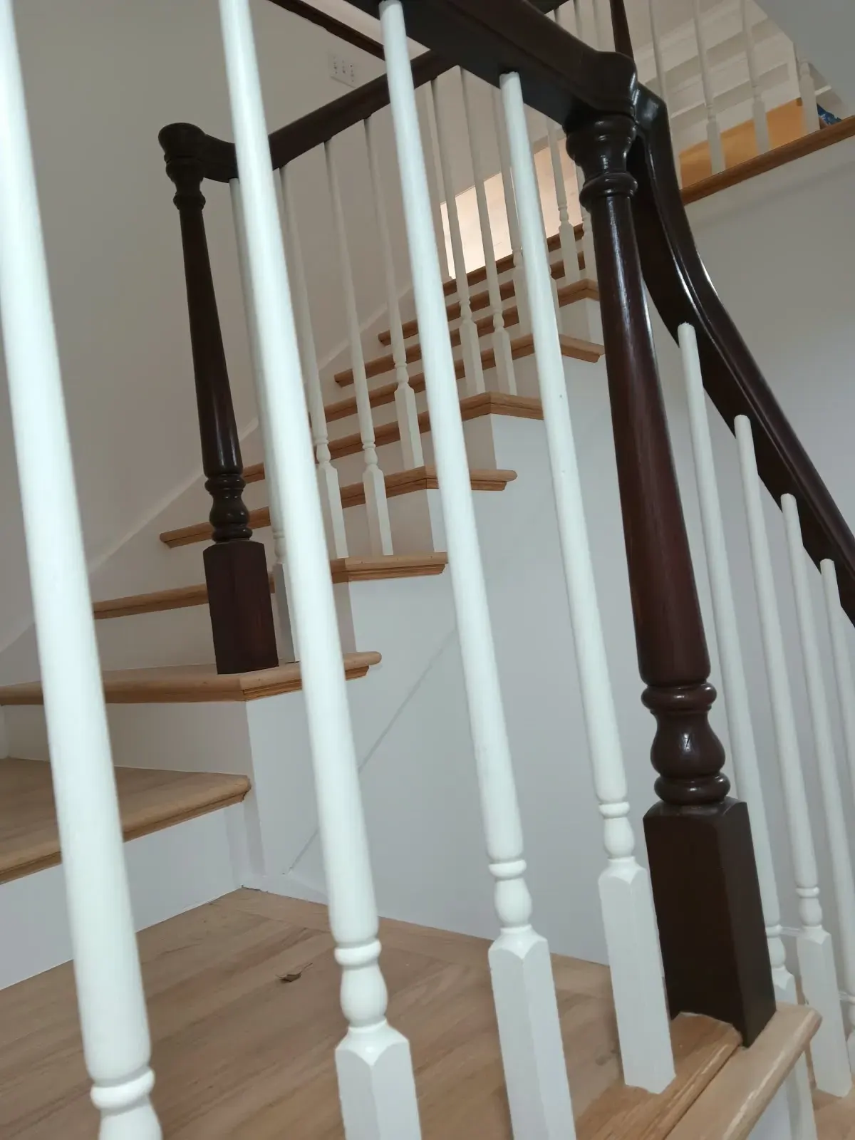 Staircase painting in San Jose, CA: white balusters and stained handrail
