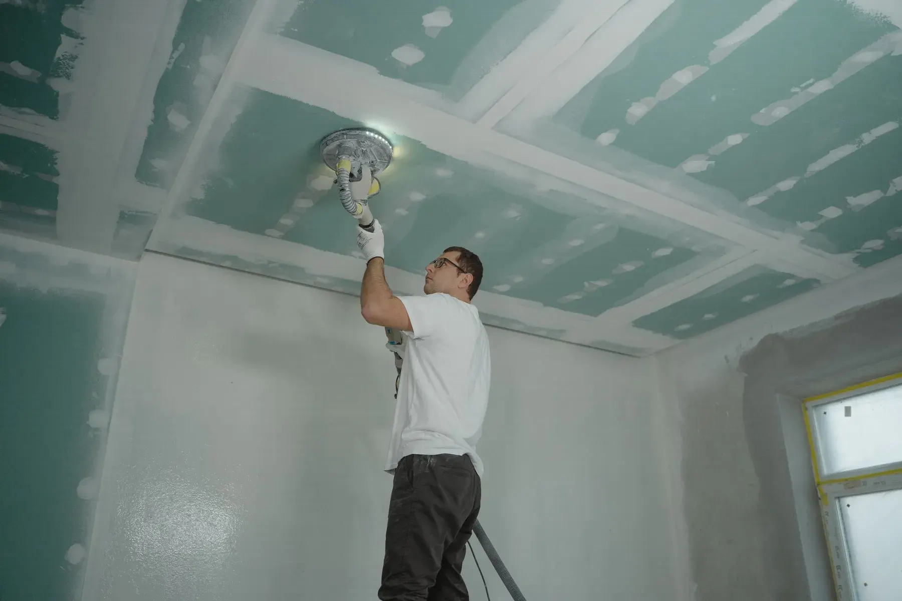 Popcorn ceiling removal in San Jose, CA: ceiling being sanded smooth