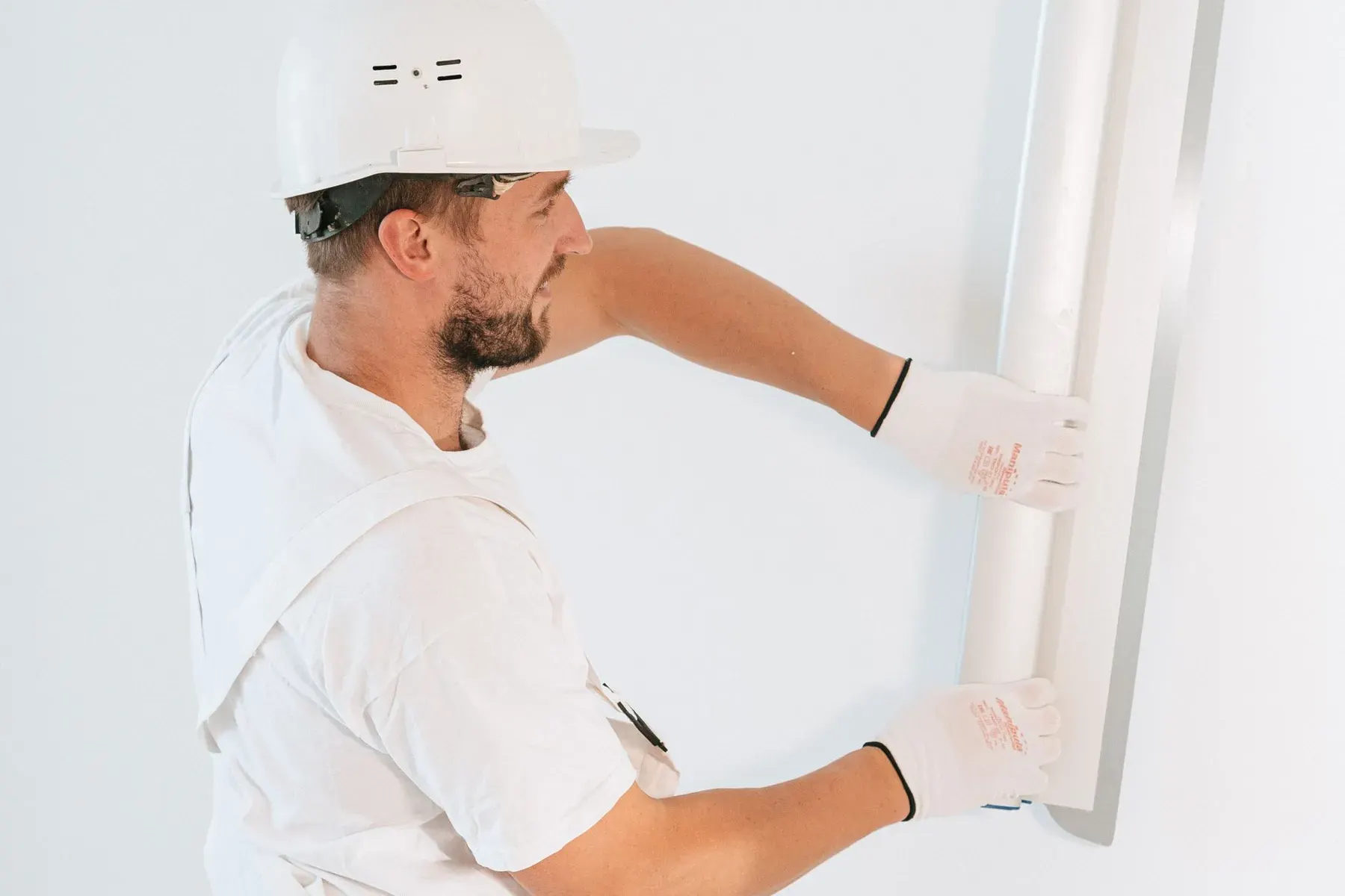 Ceiling texture in San Jose, CA: worker smoothing joint compound with a wide knife