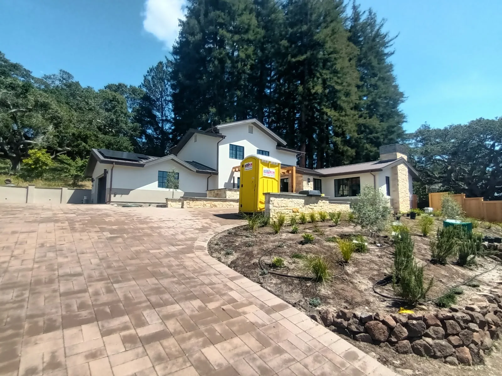 Exterior painting in San Jose, CA: painted hillside home with stone and wood details