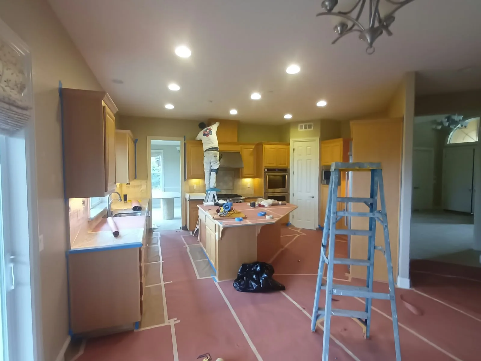 Interior painting in San Jose, CA: kitchen repaint with paper-covered floors and ladders