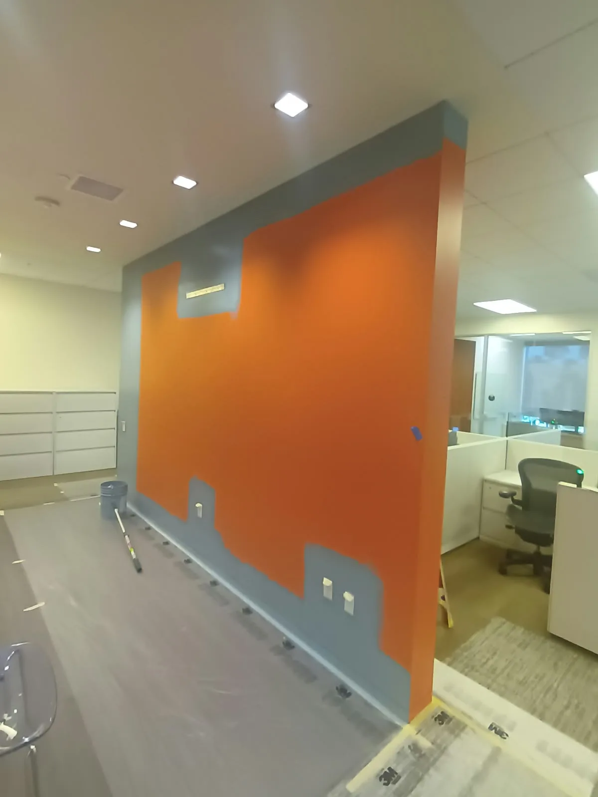 Commercial painting in San Jose, CA: office with an orange accent wall cut cleanly against gray