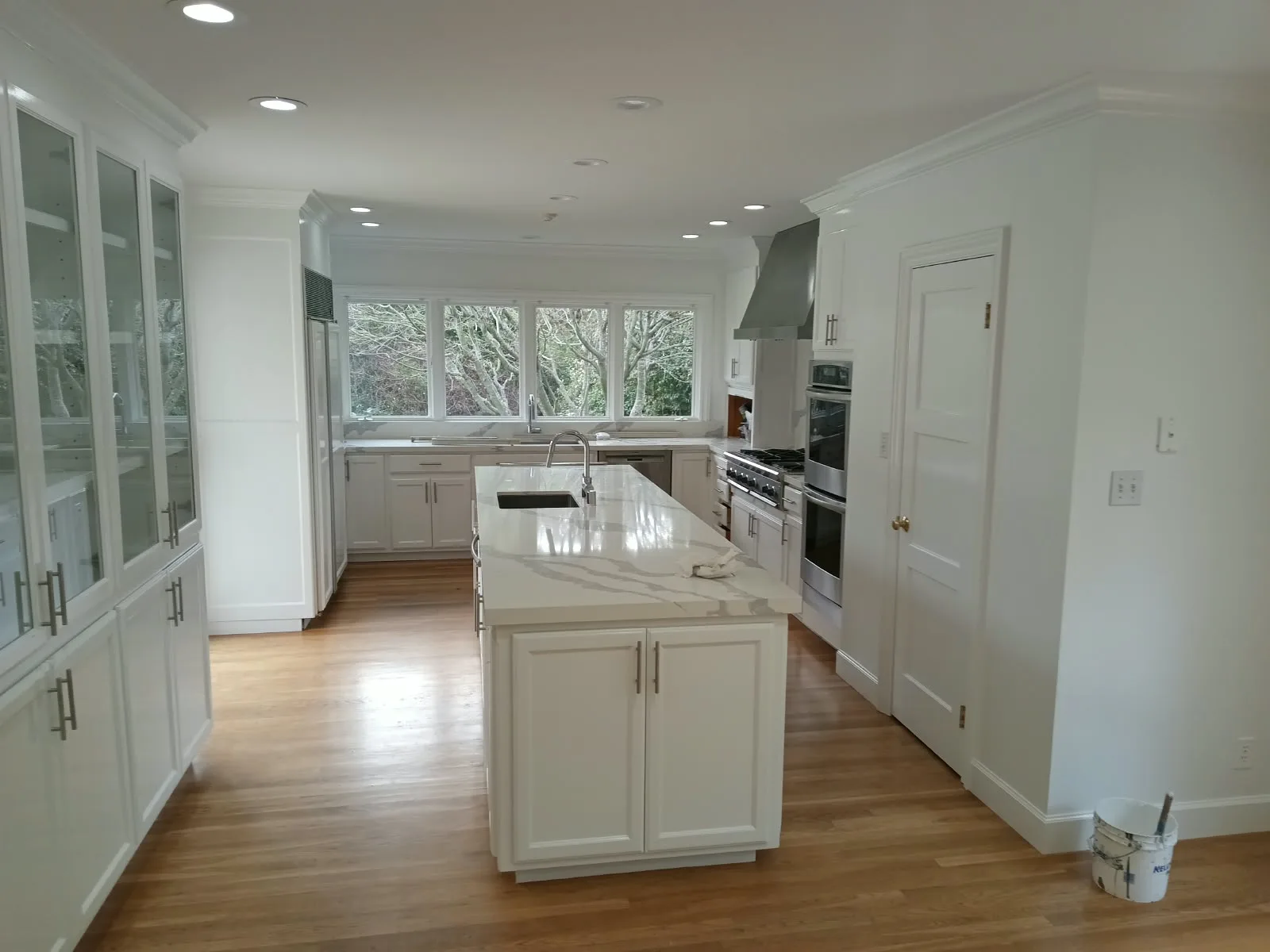 Cabinet painting in San Jose, CA: white kitchen cabinets, glass-front built-ins and island